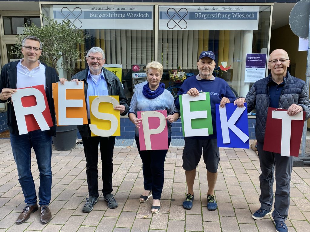 Mitglieder der Bürgerstiftung halten den Begriff "Respekt" mittels Holzbuchstaben